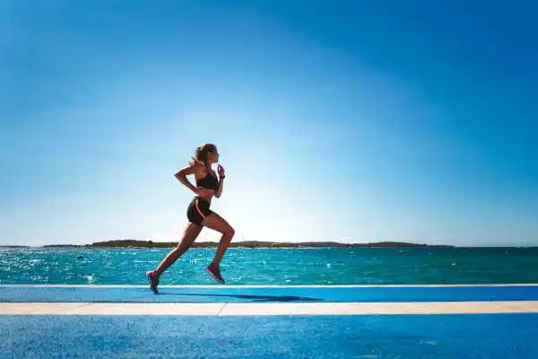 Woman running showing strong leg muscle Irthlingborough